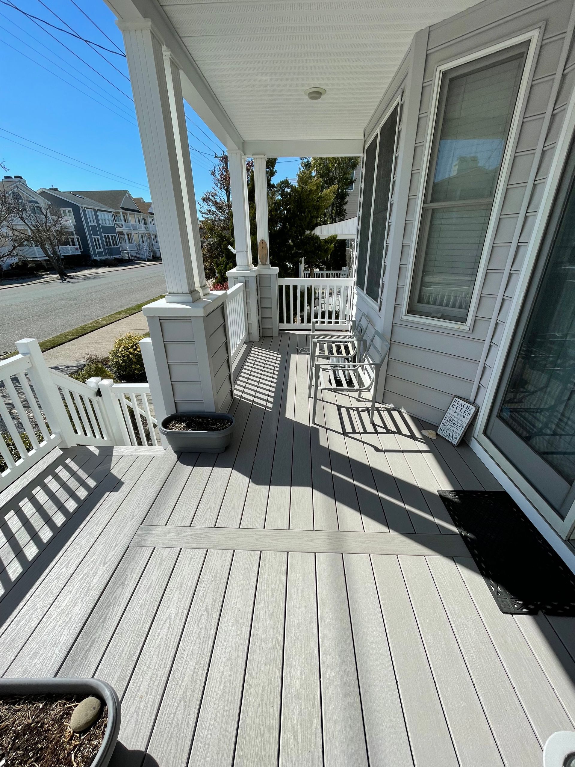 A porch with chairs and a planter on it