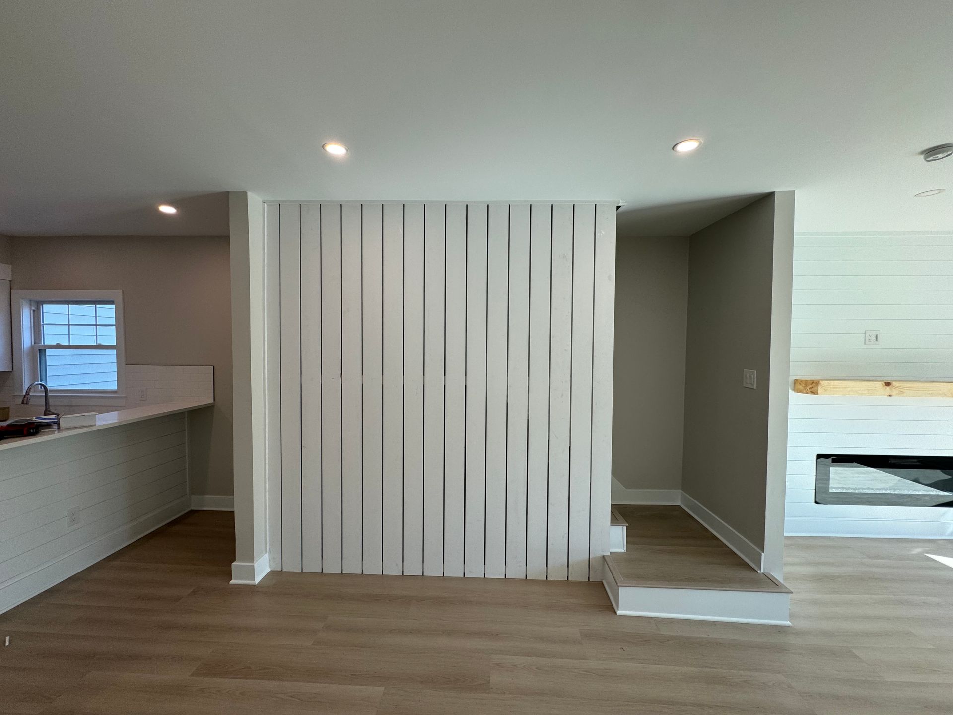 A living room with a fireplace and a white wall.