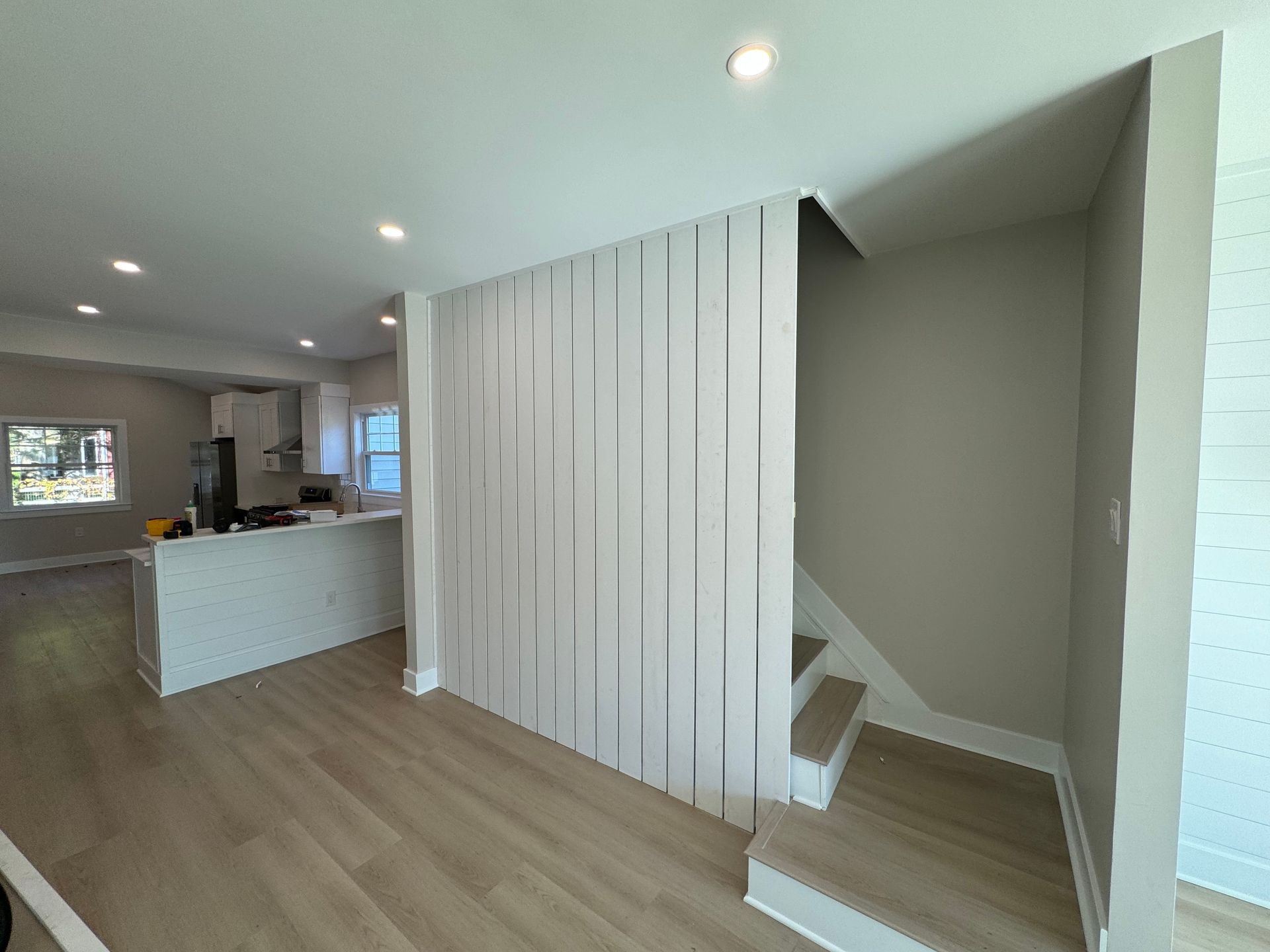 A living room with hardwood floors and stairs leading up to the second floor.
