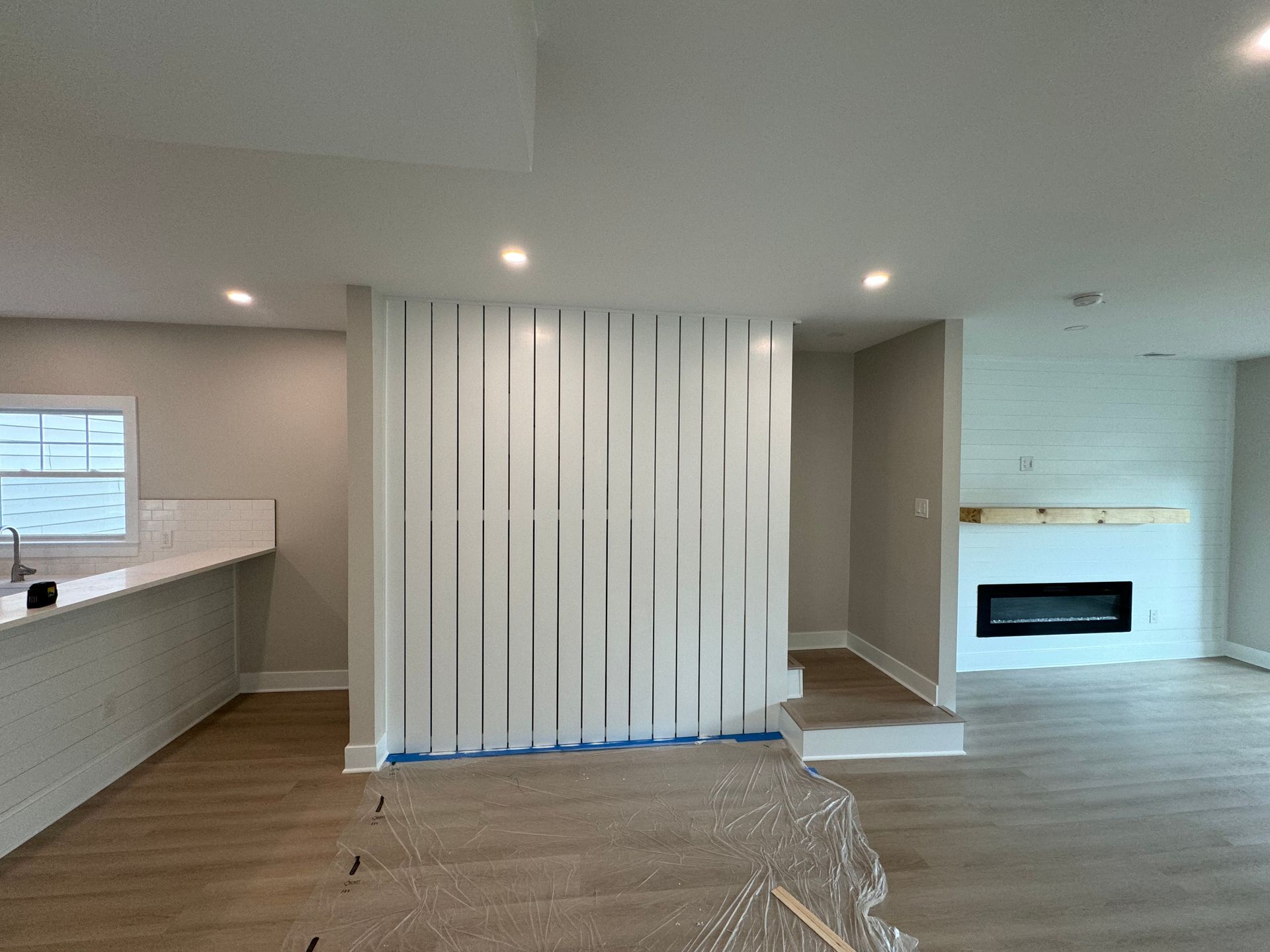 A living room with a fireplace and a wall divider.