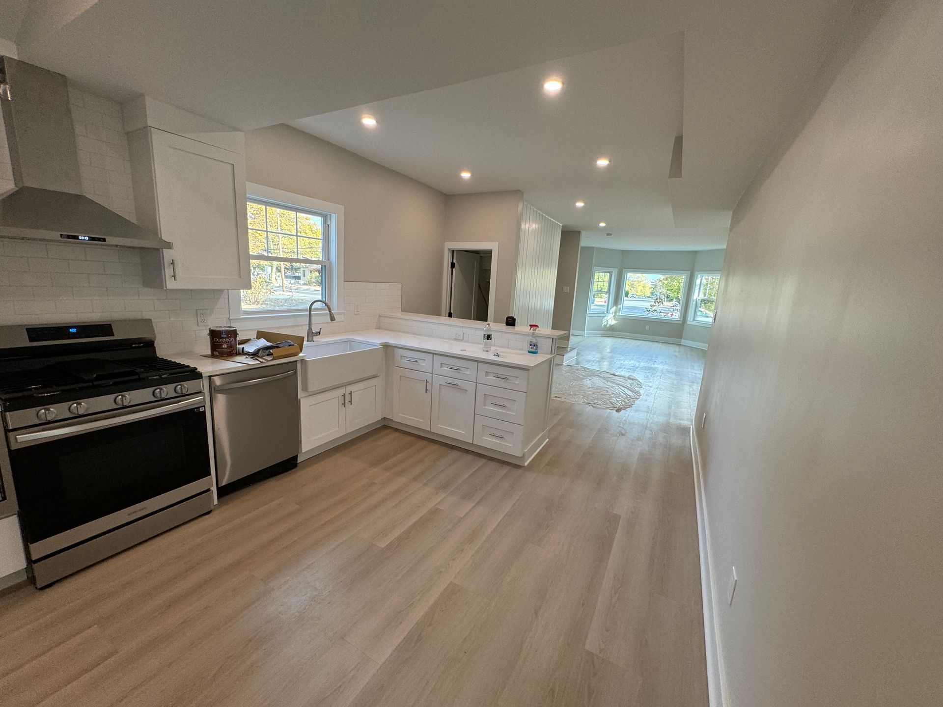 A kitchen with white cabinets , a stove , a dishwasher , and a sink.
