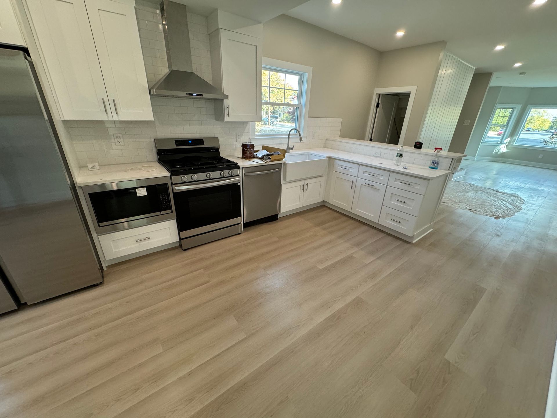 A kitchen with stainless steel appliances and white cabinets.