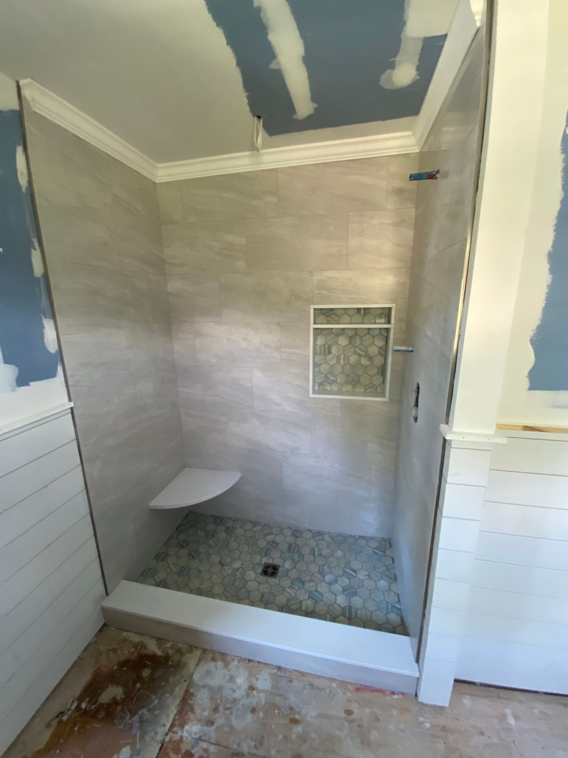 A bathroom with a walk in shower under construction.