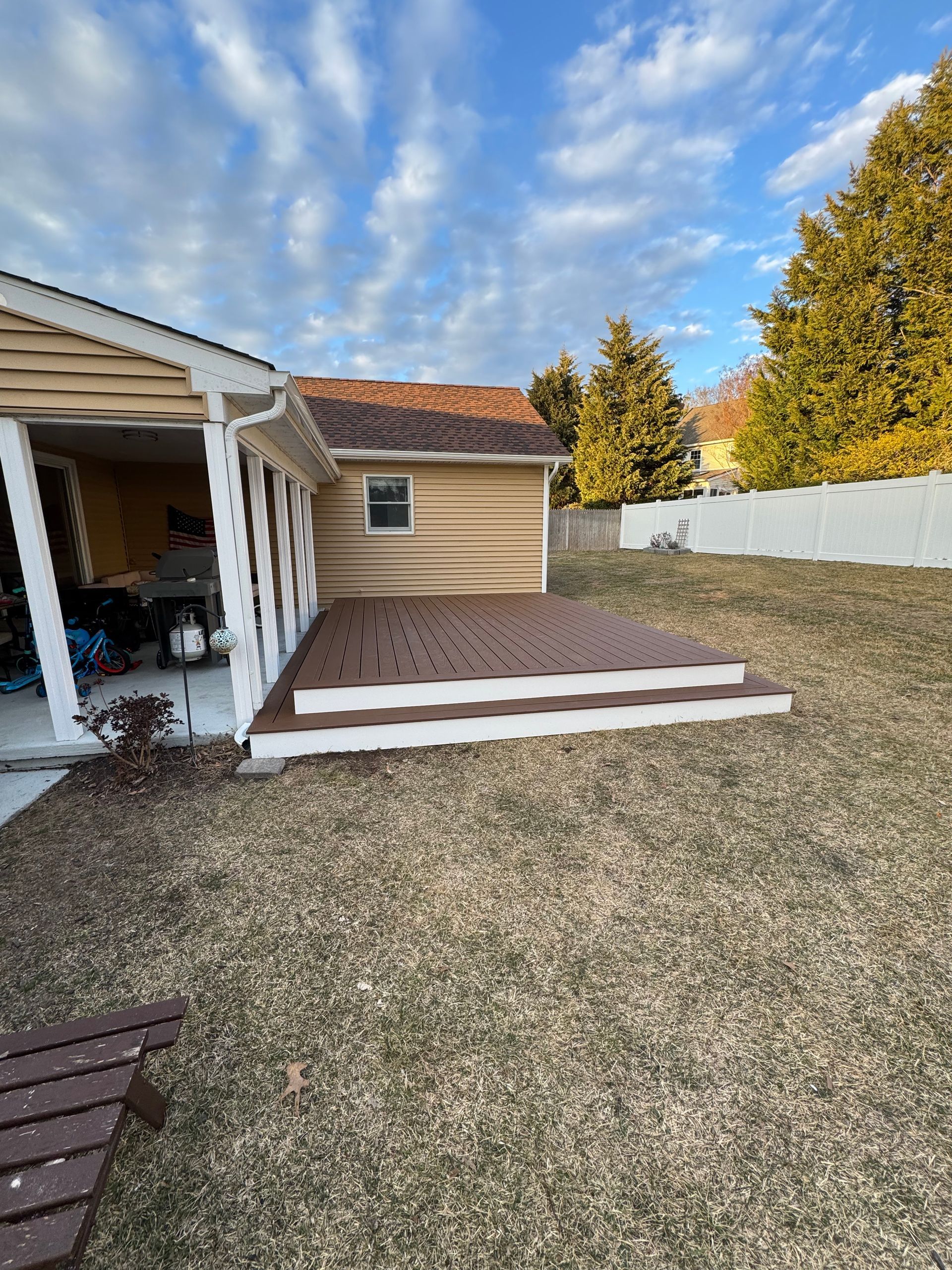 A house with a deck and stairs in the backyard.