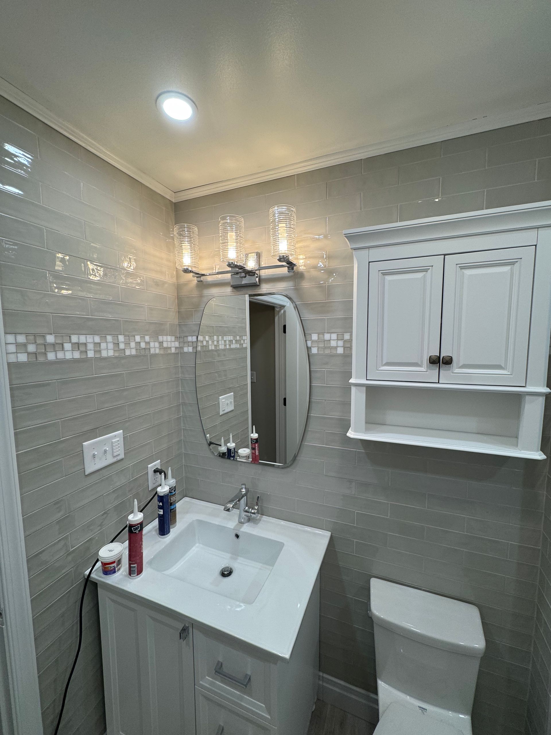 A bathroom with a sink , toilet and mirror.