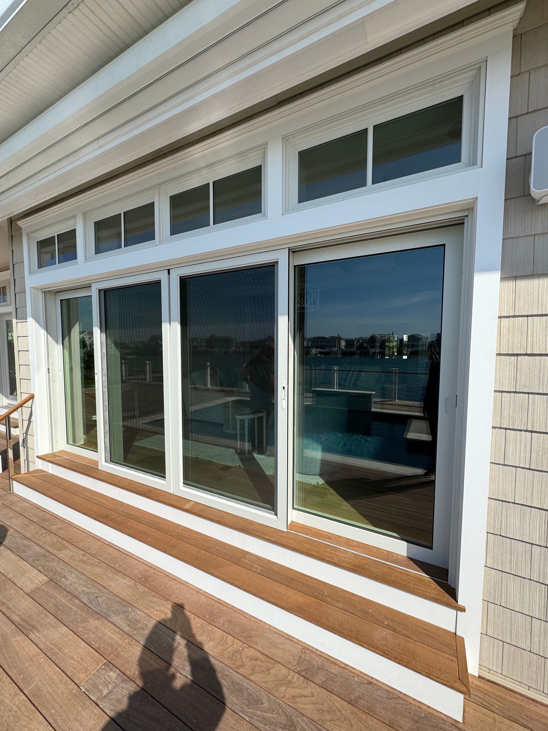 A house with a lot of windows and a wooden deck
