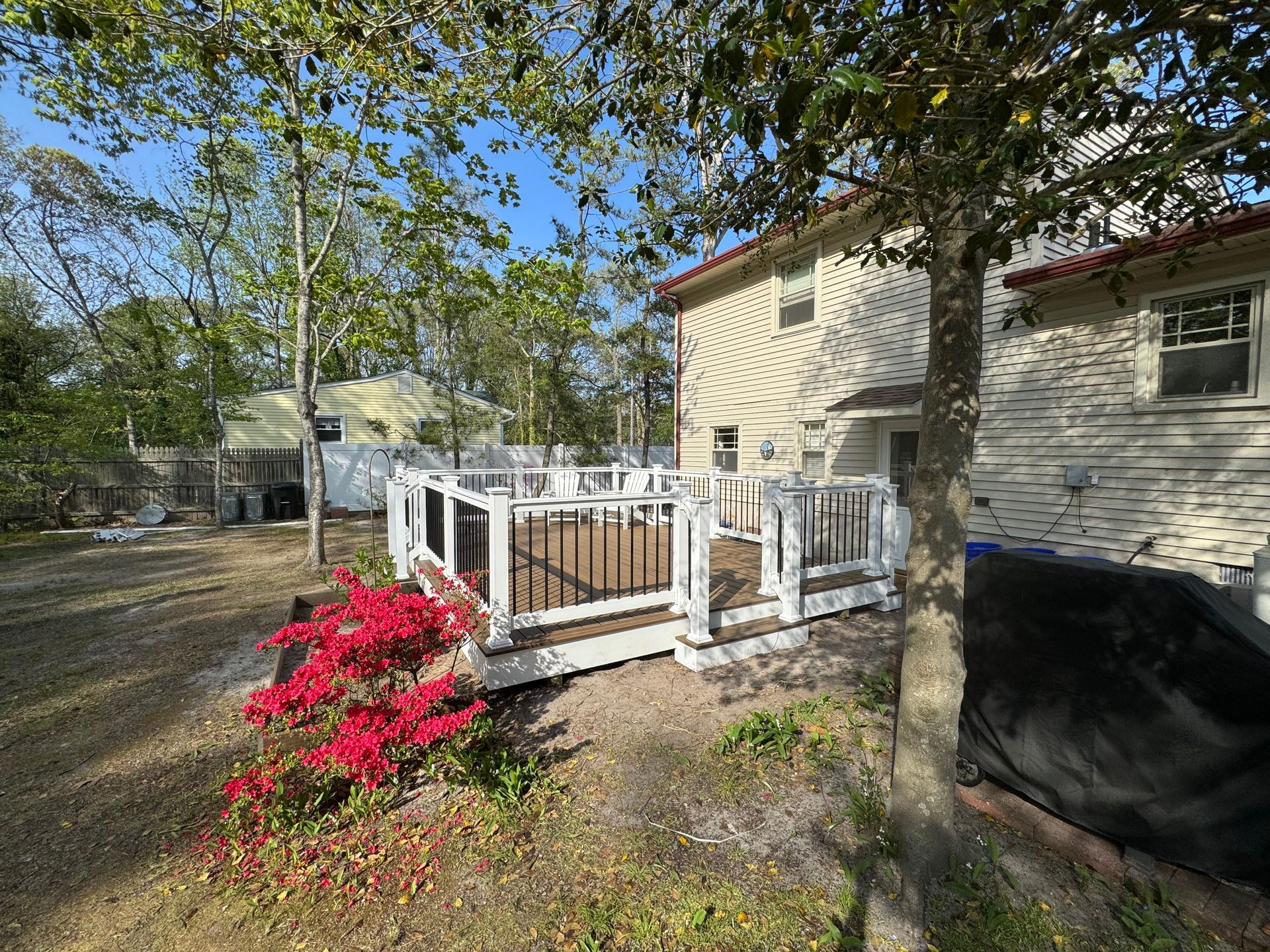 There is a large deck in the backyard of a house.
