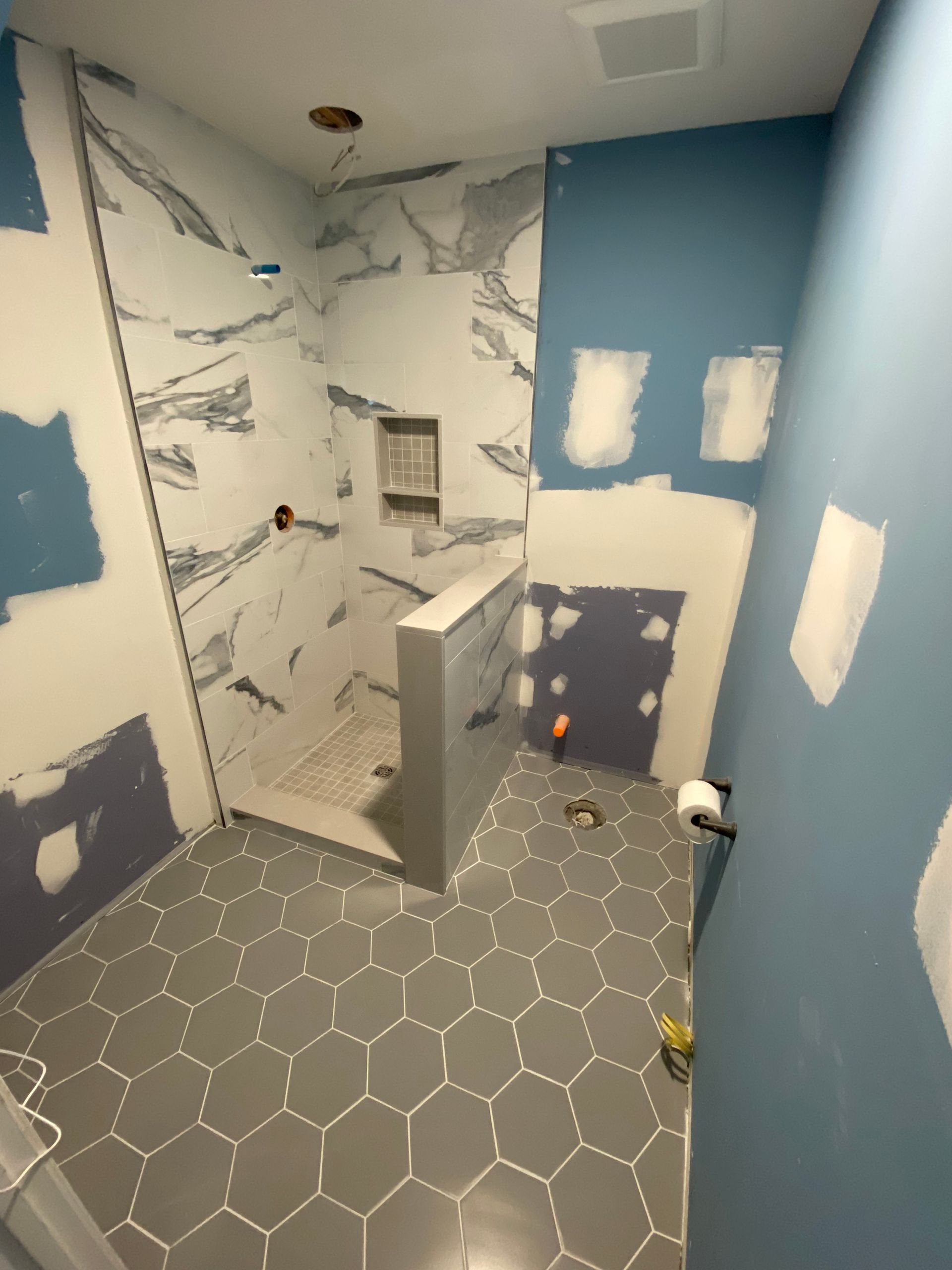 A bathroom that is being remodeled with a walk in shower