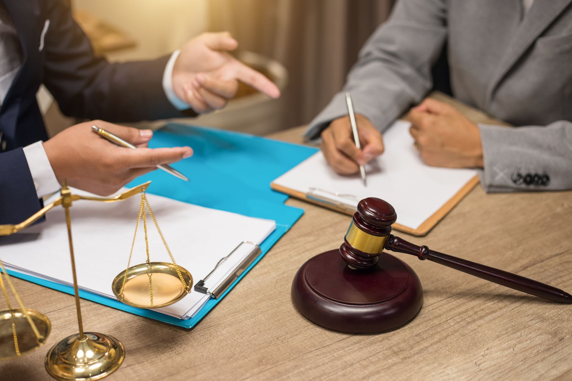 Lawyer and client talking with gavel and balance in office.