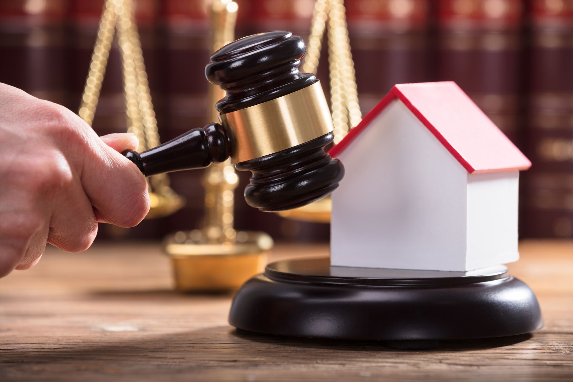 Hand striking wooden gavel on miniature house, representing chapter 7 bankruptcy. Hand striking wooden gavel on miniature house, representing chapter 7 bankruptcy.