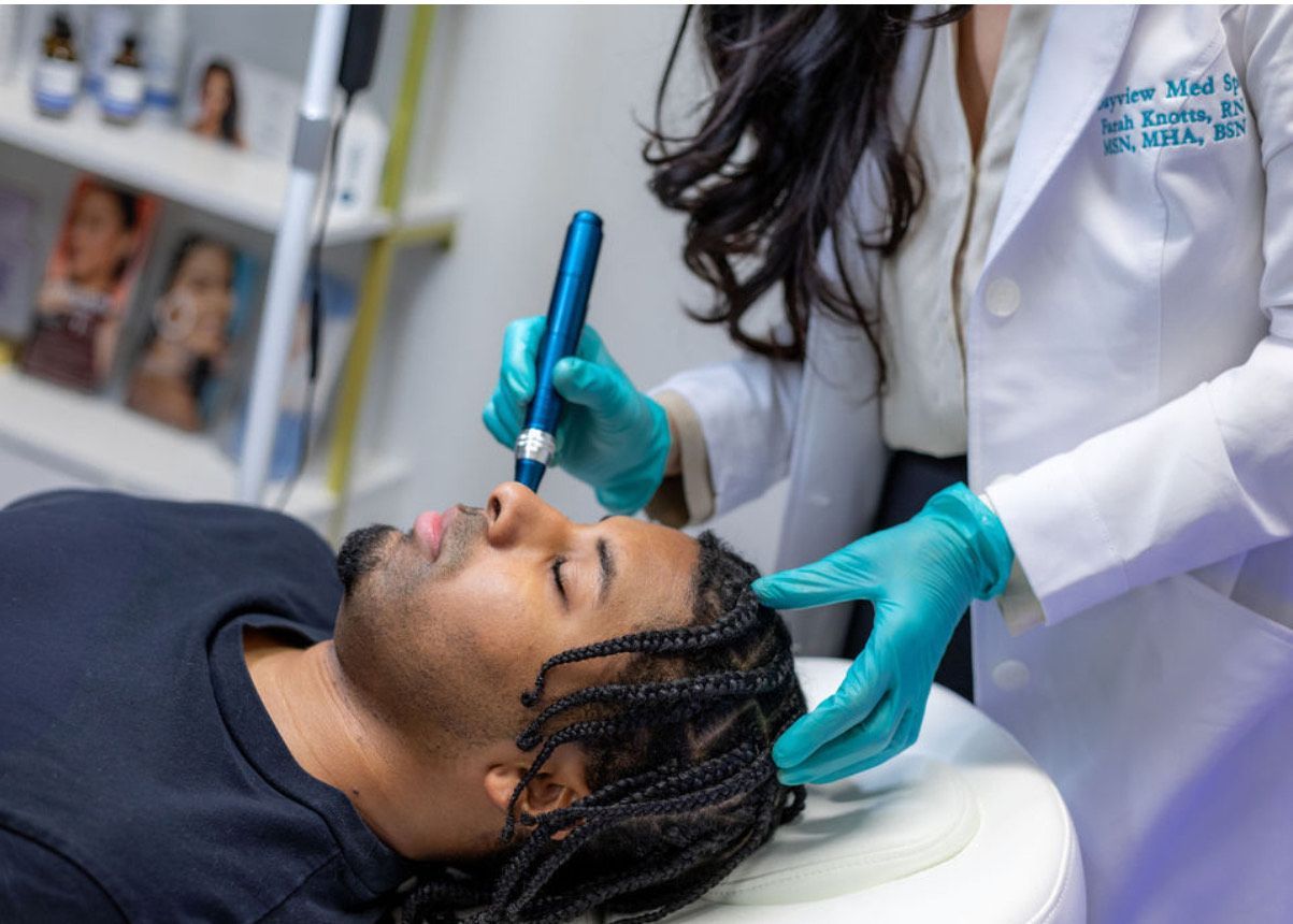 A man is getting a treatment on his face by a doctor.