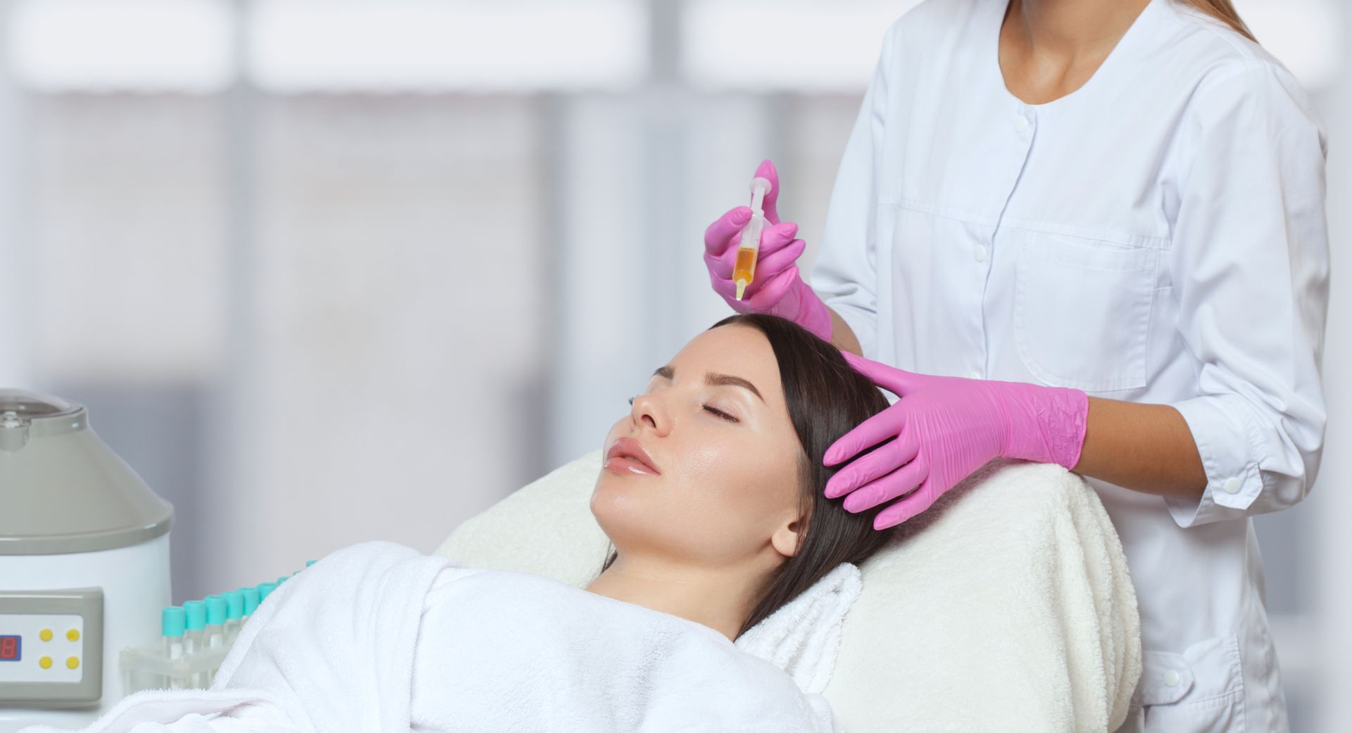 A woman is getting a hair treatment at a beauty salon.