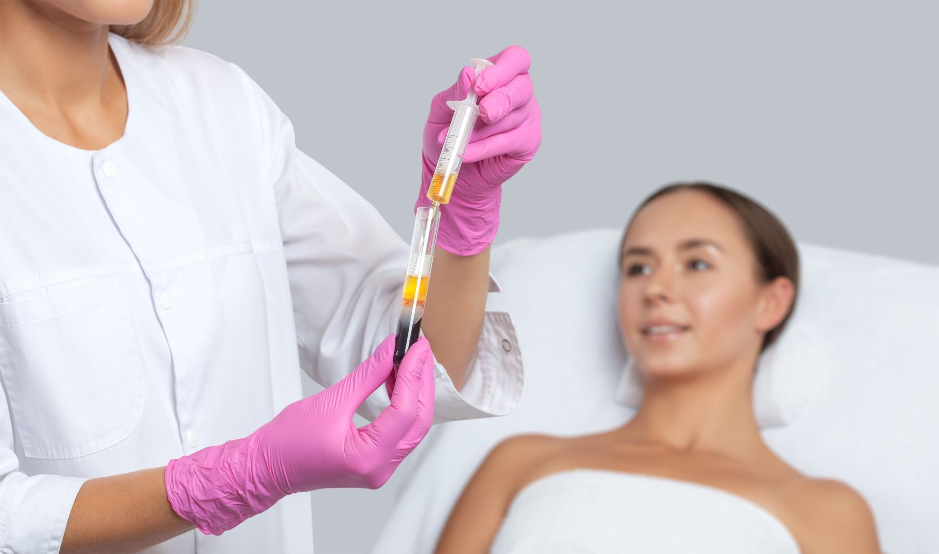 A woman is laying in a bed getting an injection from a doctor.