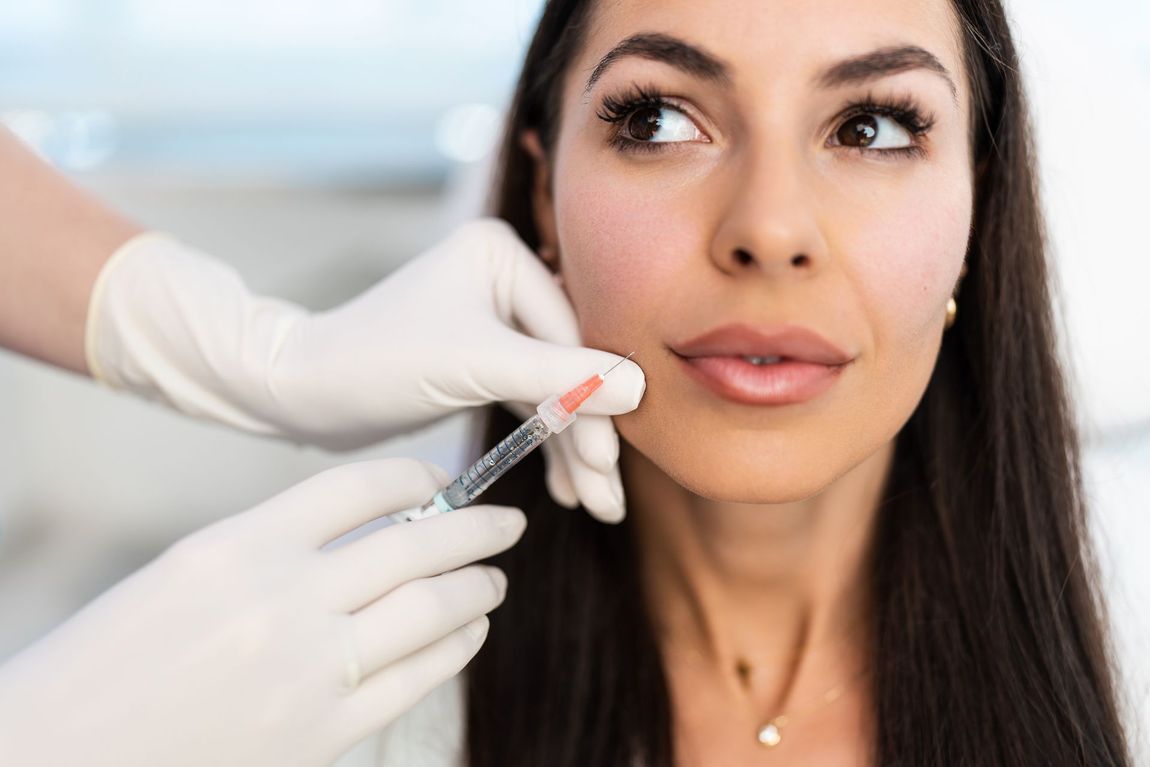 A woman is getting a botox injection in her face.