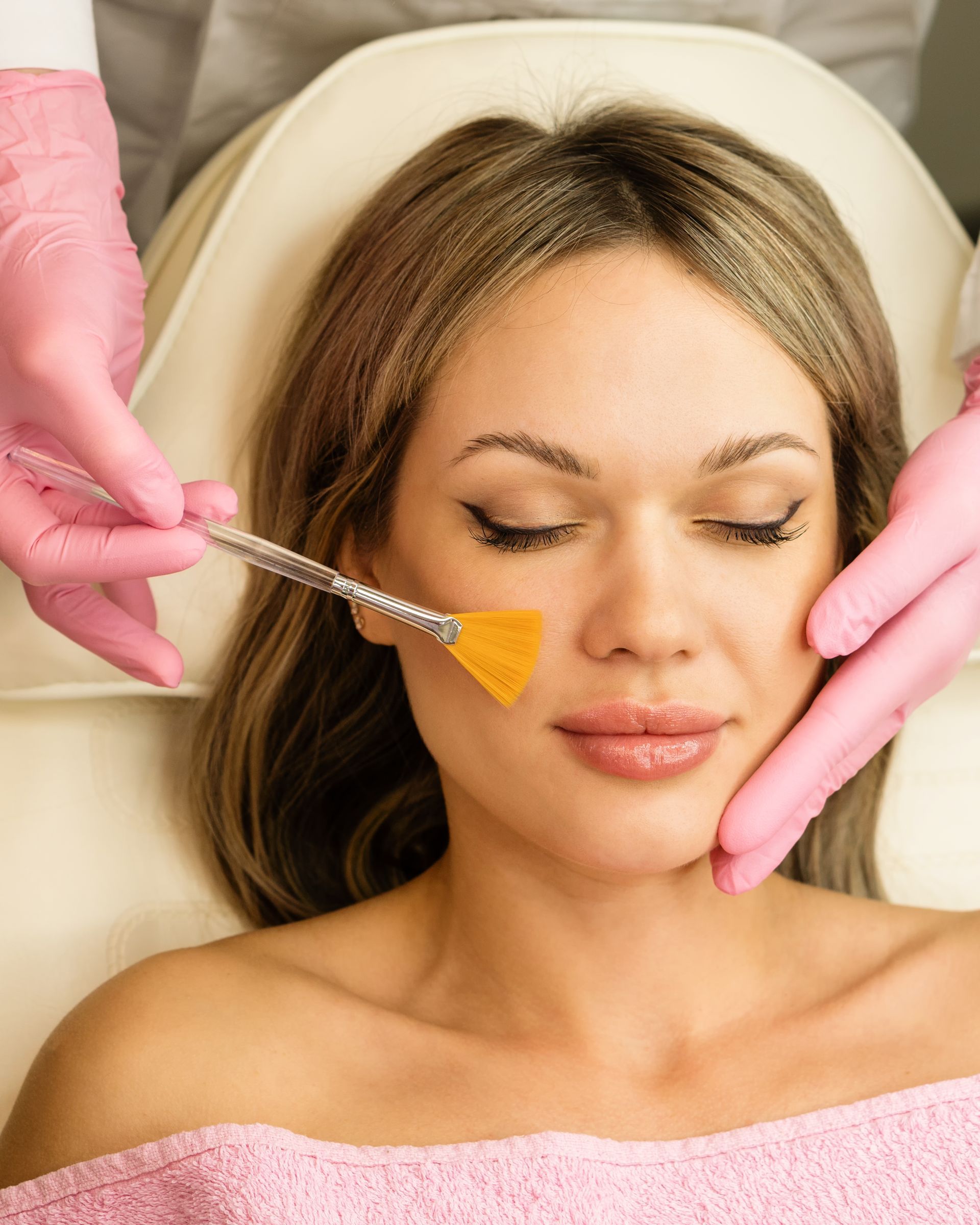 A woman is getting a facial treatment at a beauty salon.