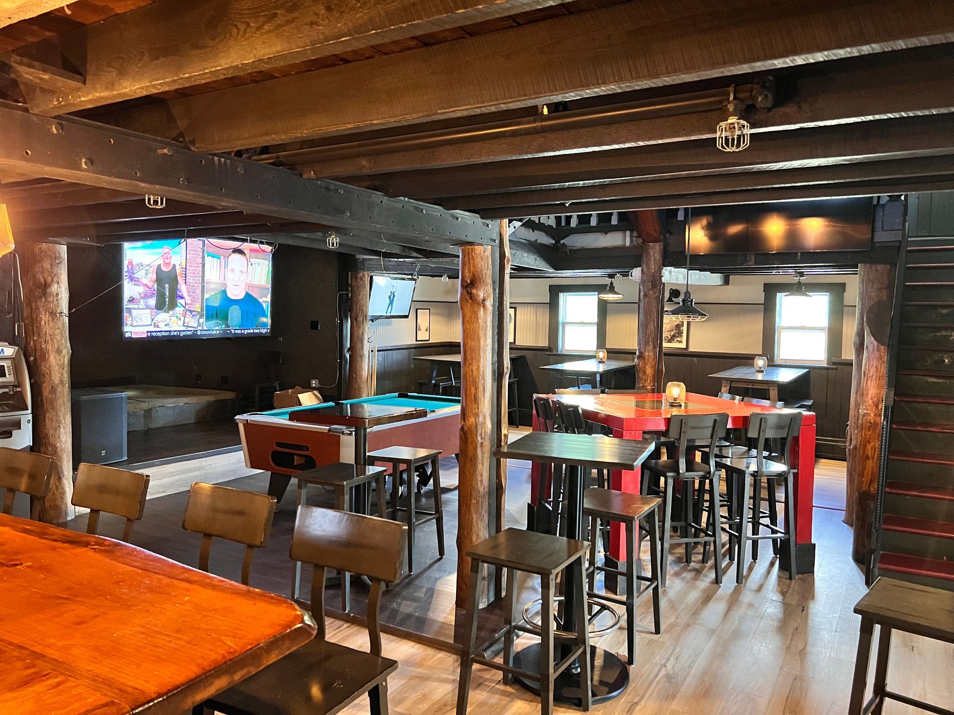 A large room with tables and chairs and a pool table.
