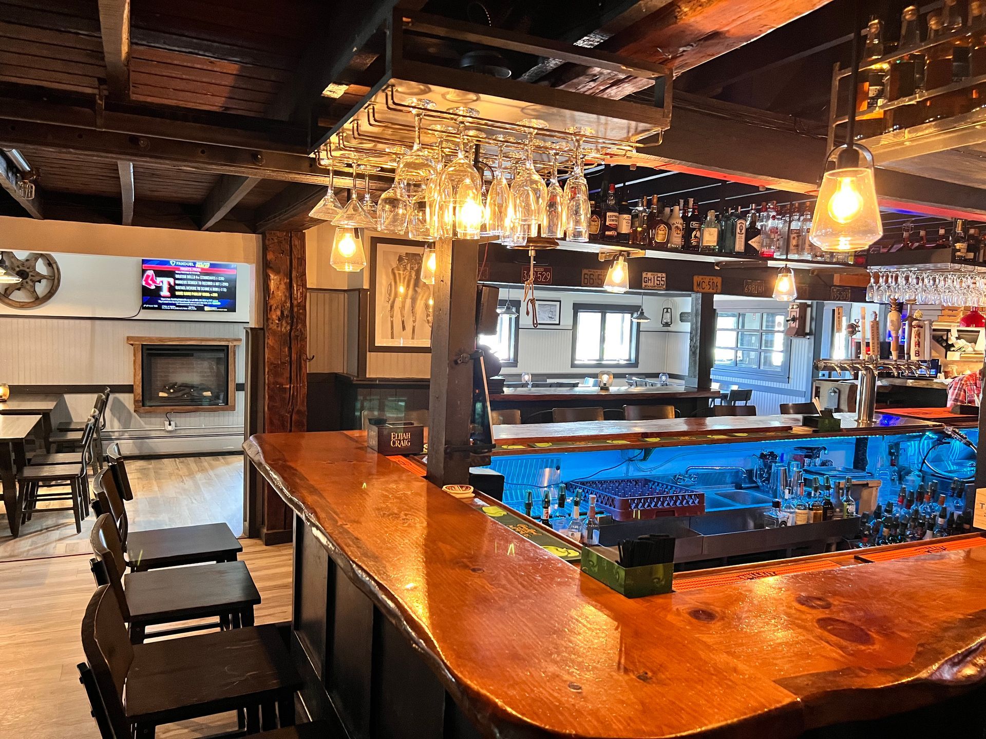 A bar in a restaurant with a lot of glasses on it.