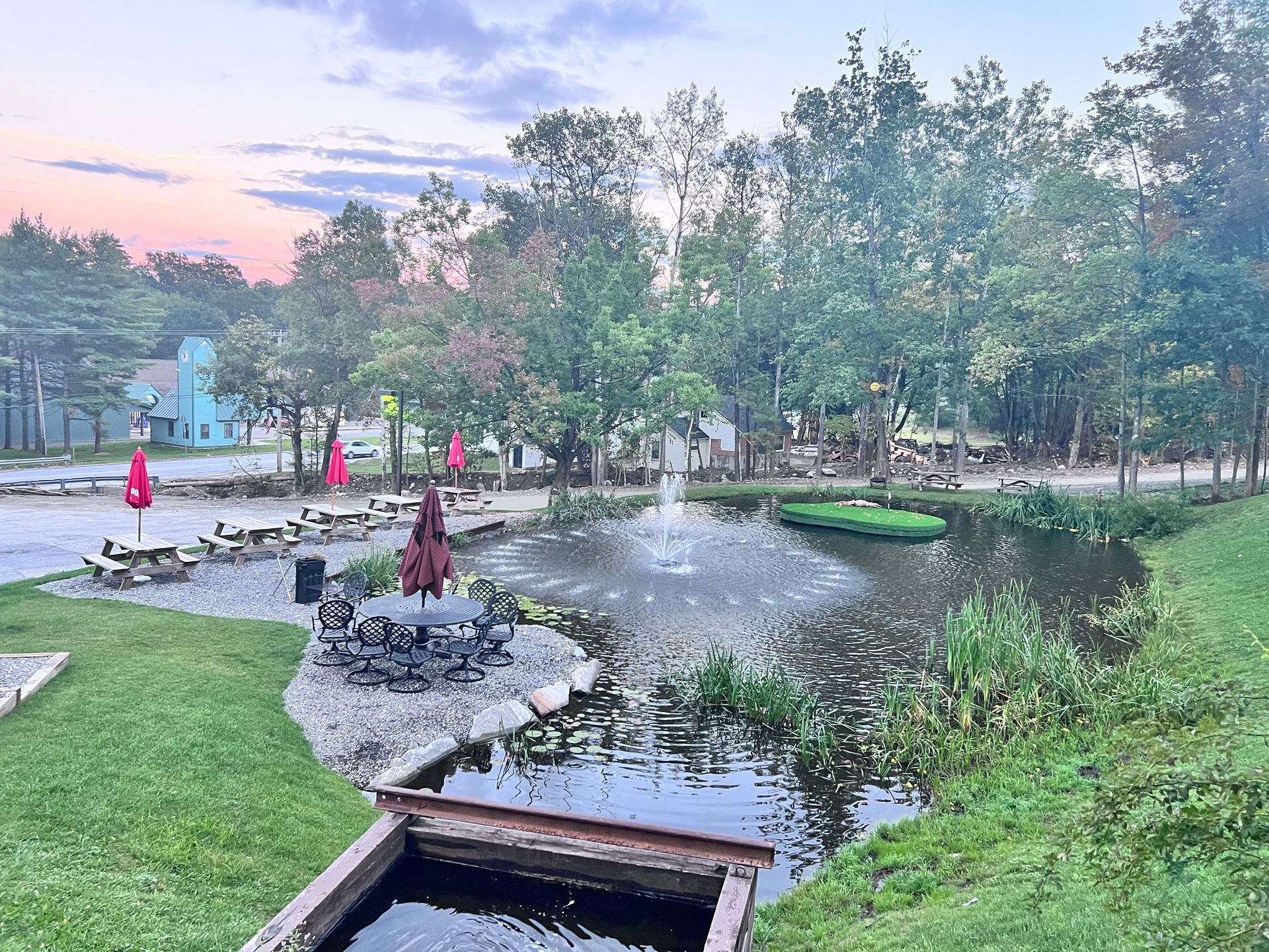 There is a pond with a fountain in the middle of the park.