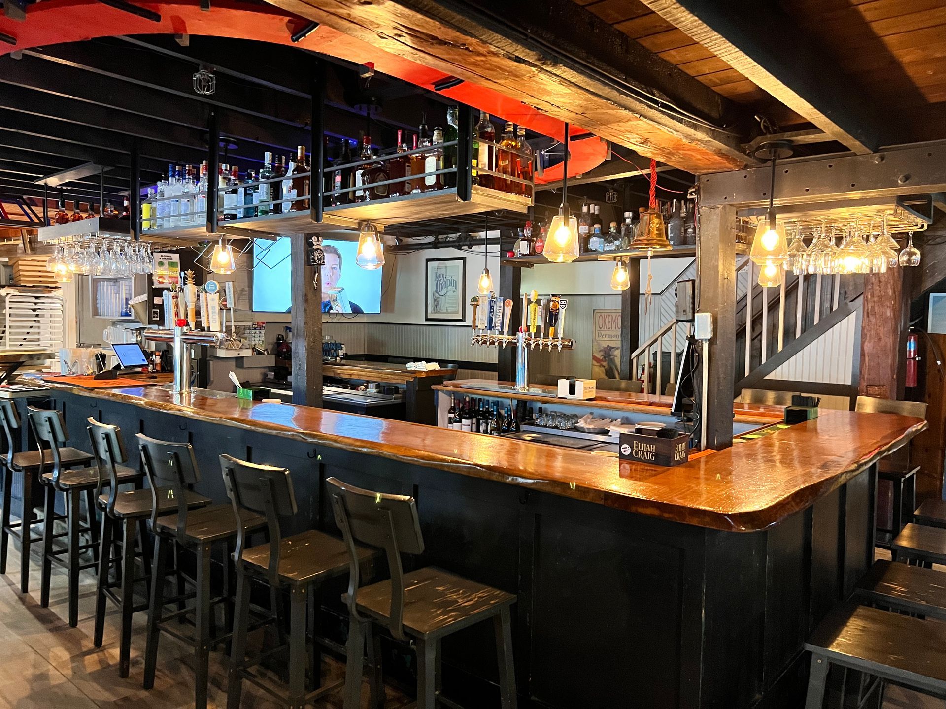 A long bar with a lot of stools in a restaurant.