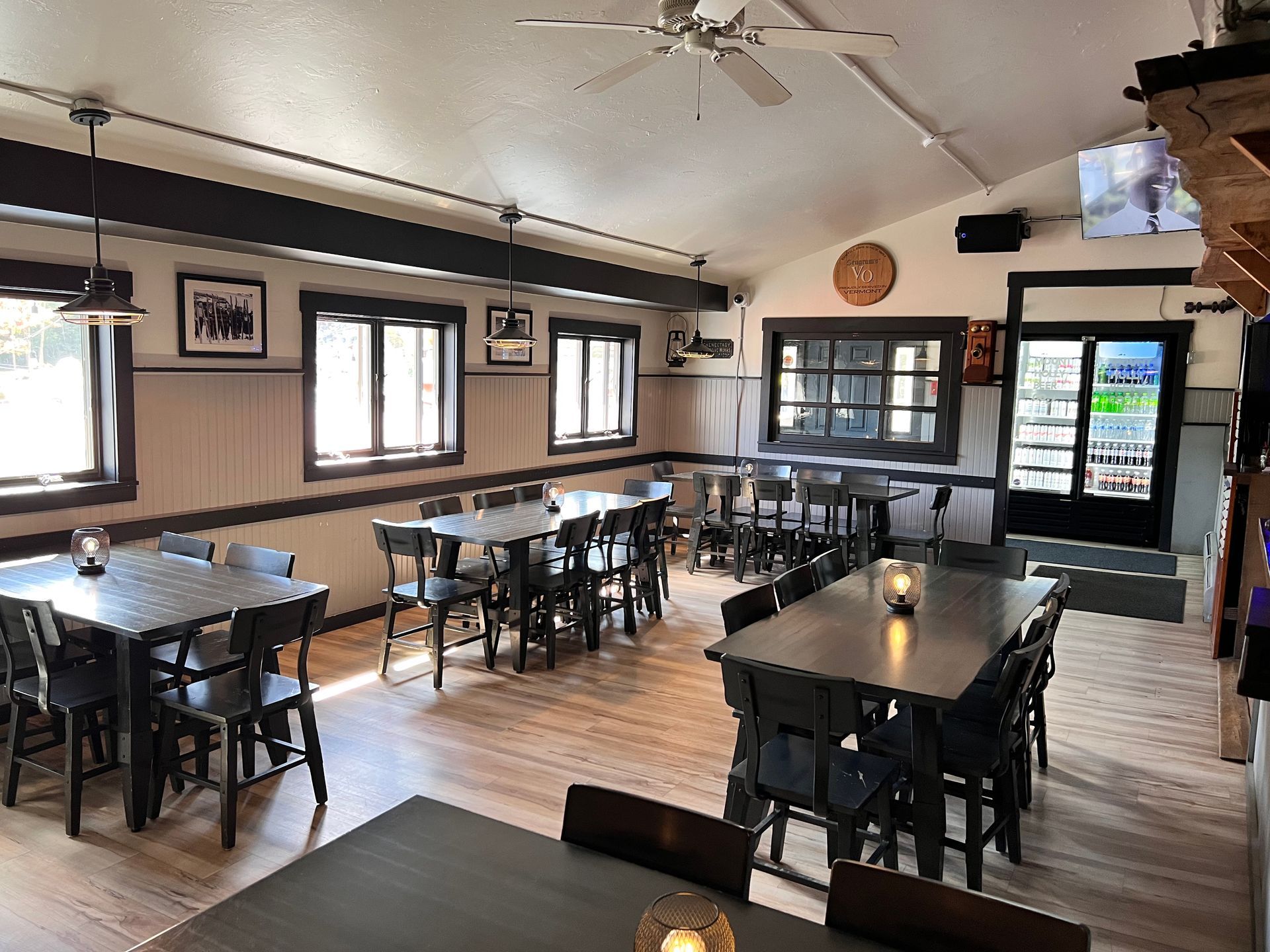 A restaurant with tables and chairs and a ceiling fan.