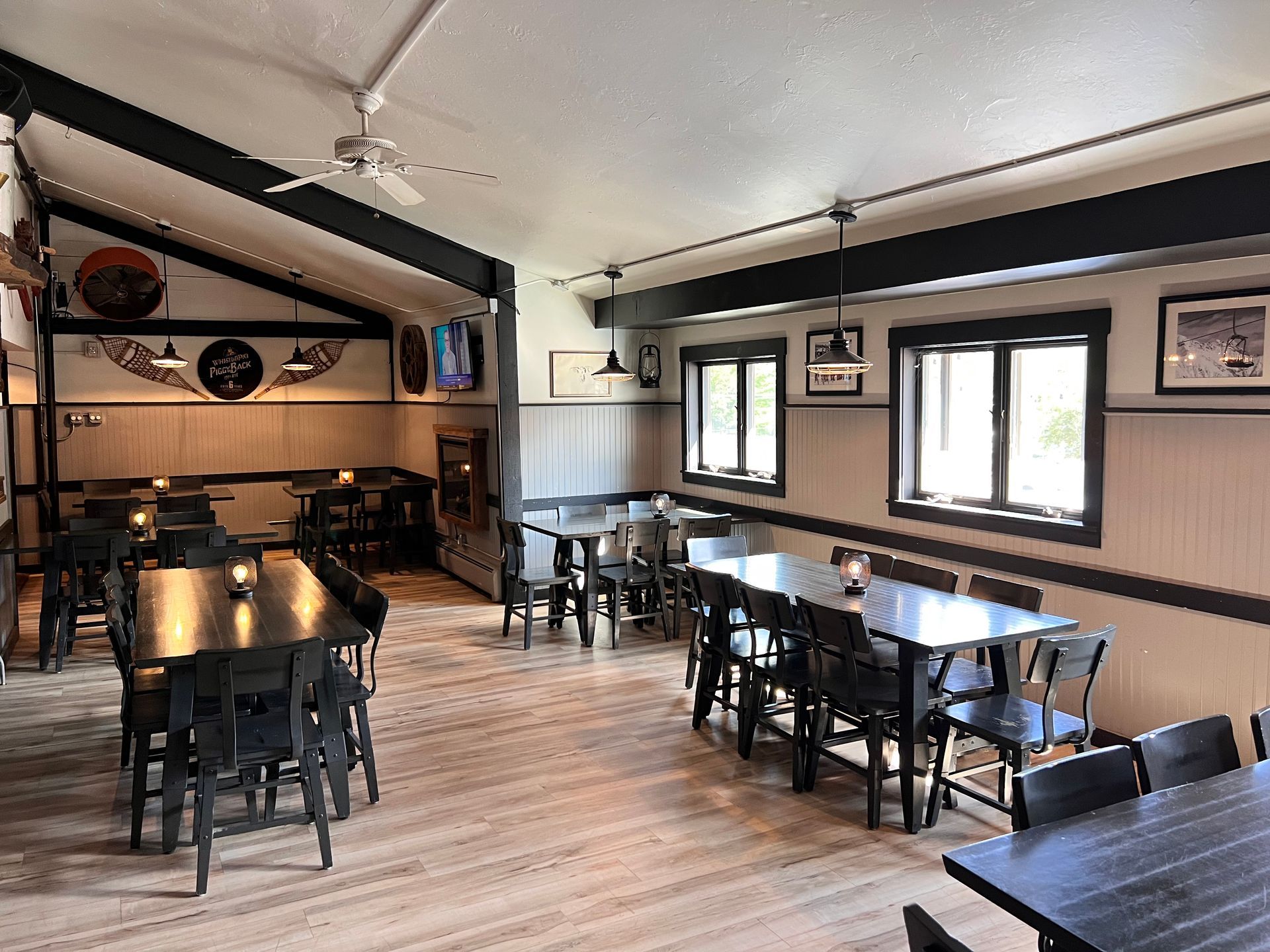 A restaurant with tables and chairs and a ceiling fan.