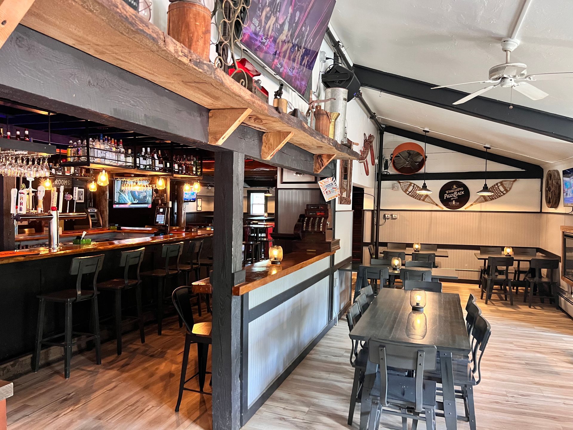 A restaurant with tables and chairs and a bar.