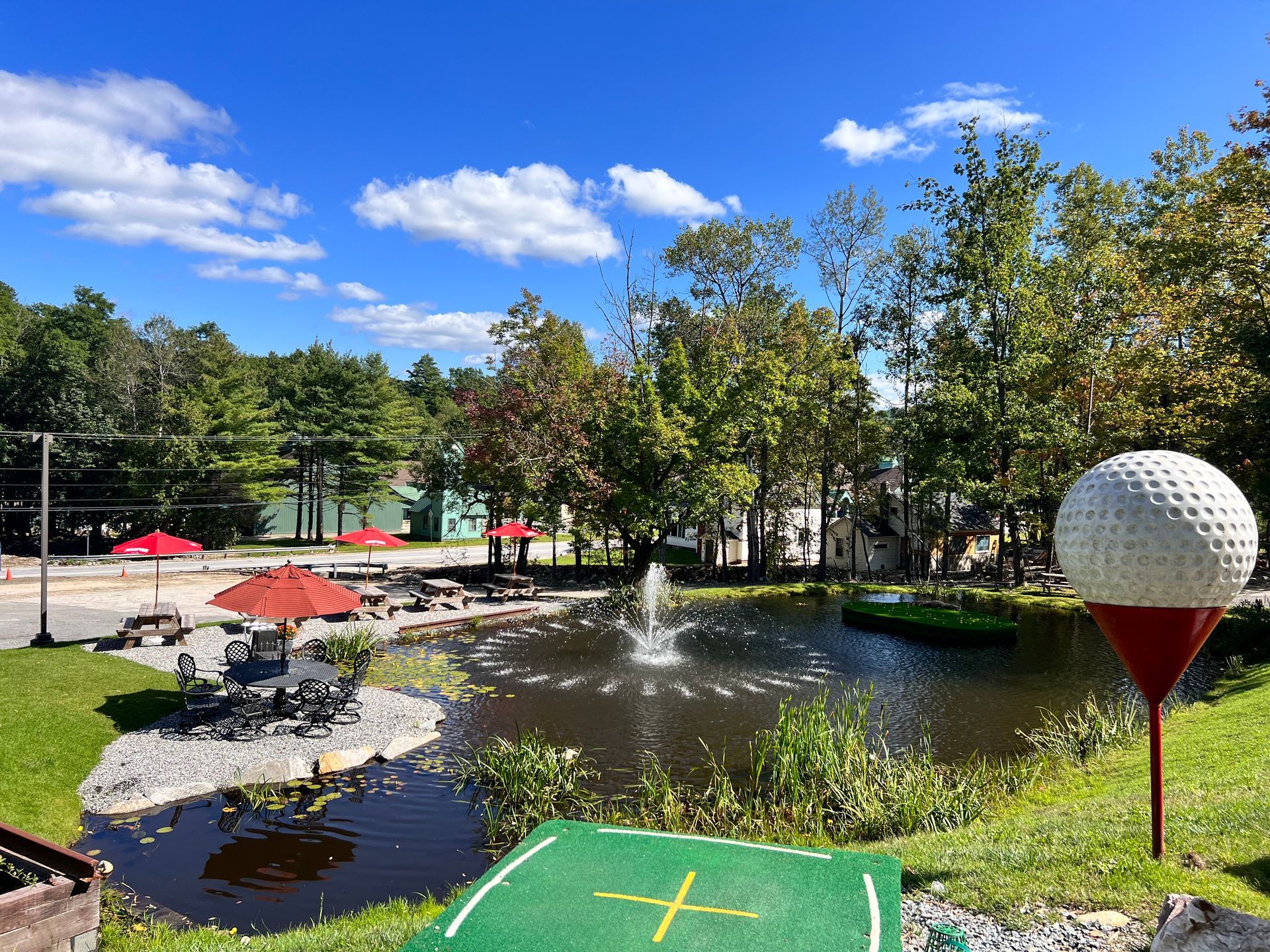 A golf ball on a tee next to a pond