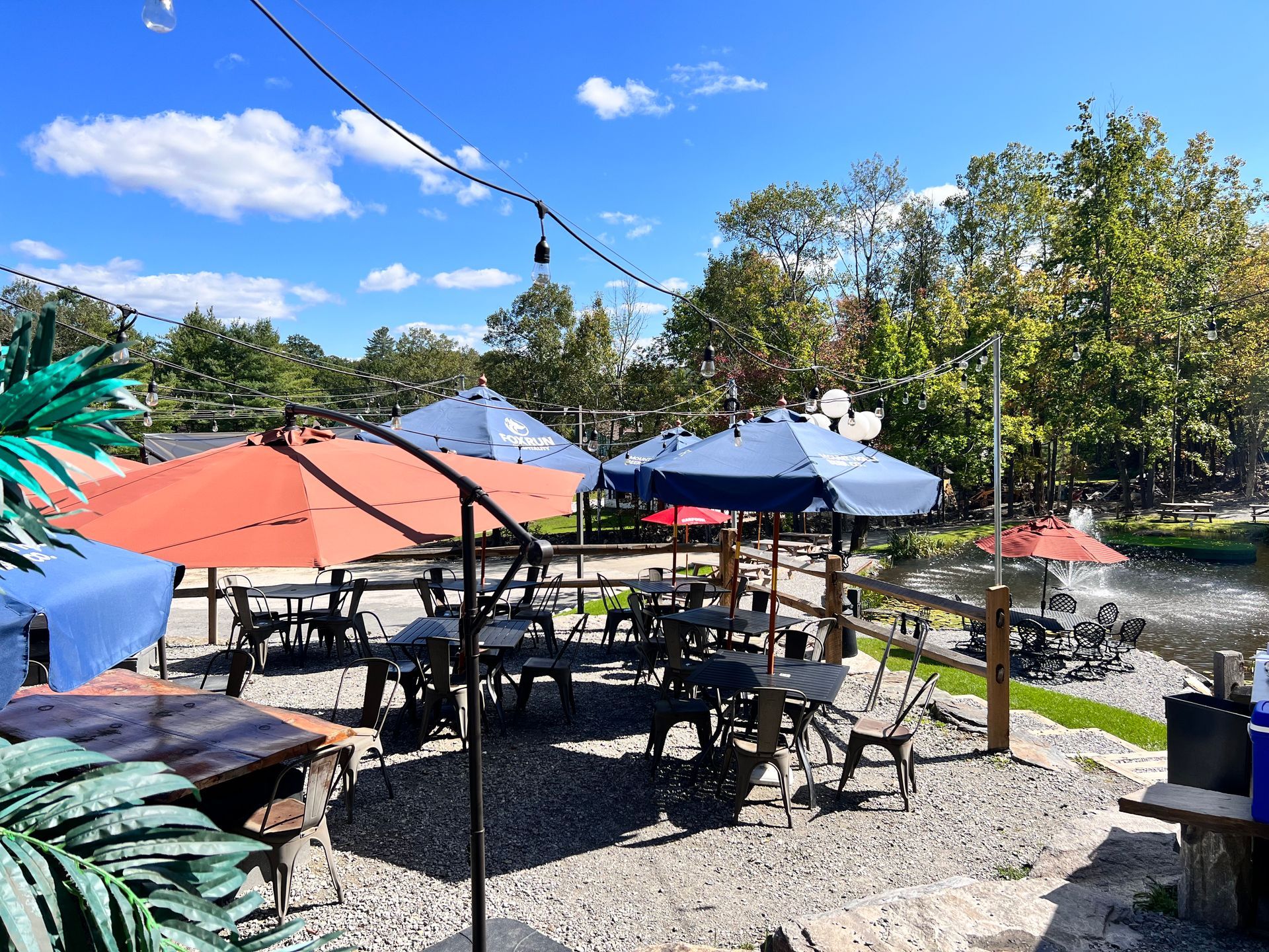 A patio with tables and chairs and umbrellas on a sunny day.