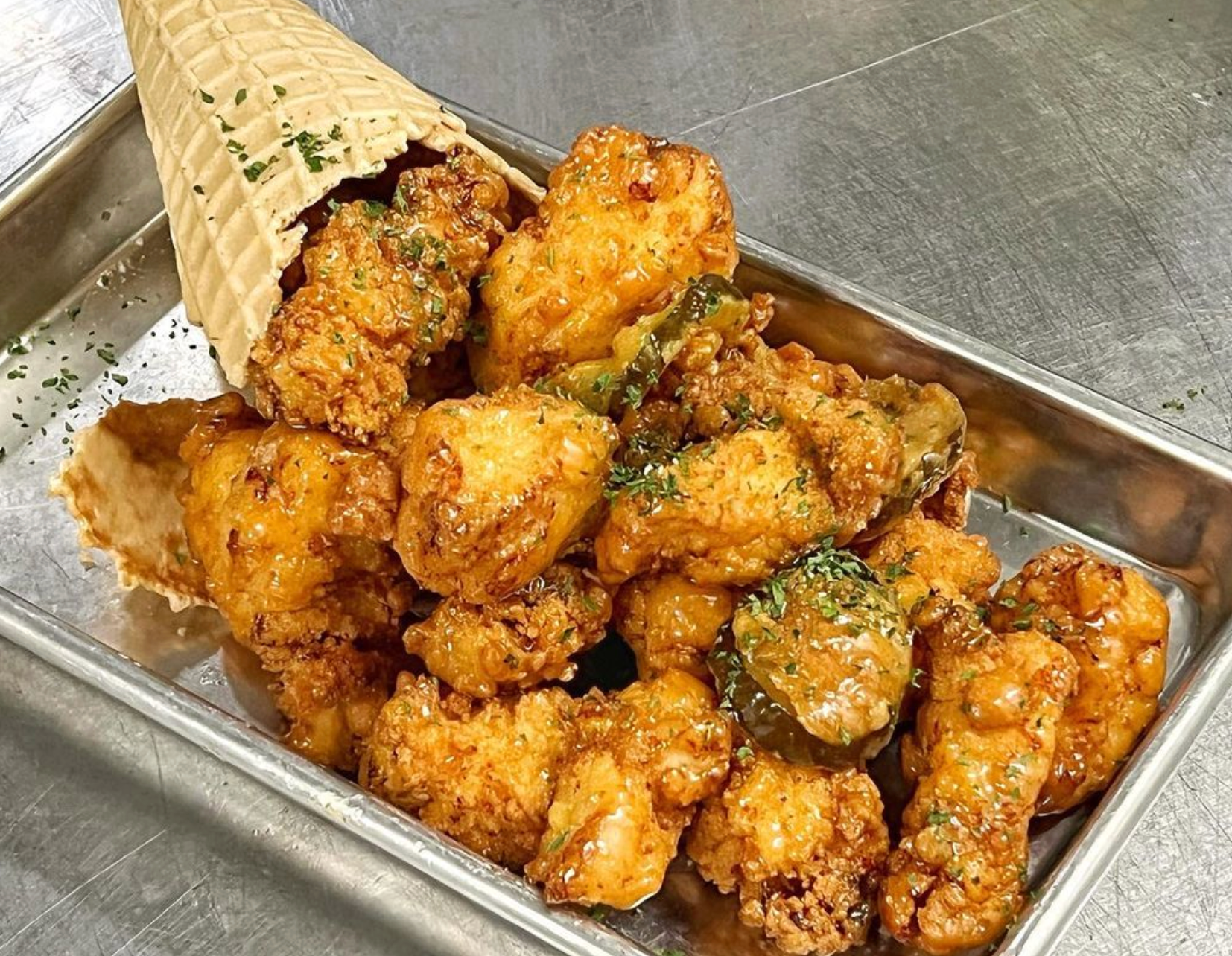 A tray of fried chicken and an ice cream cone on a table.