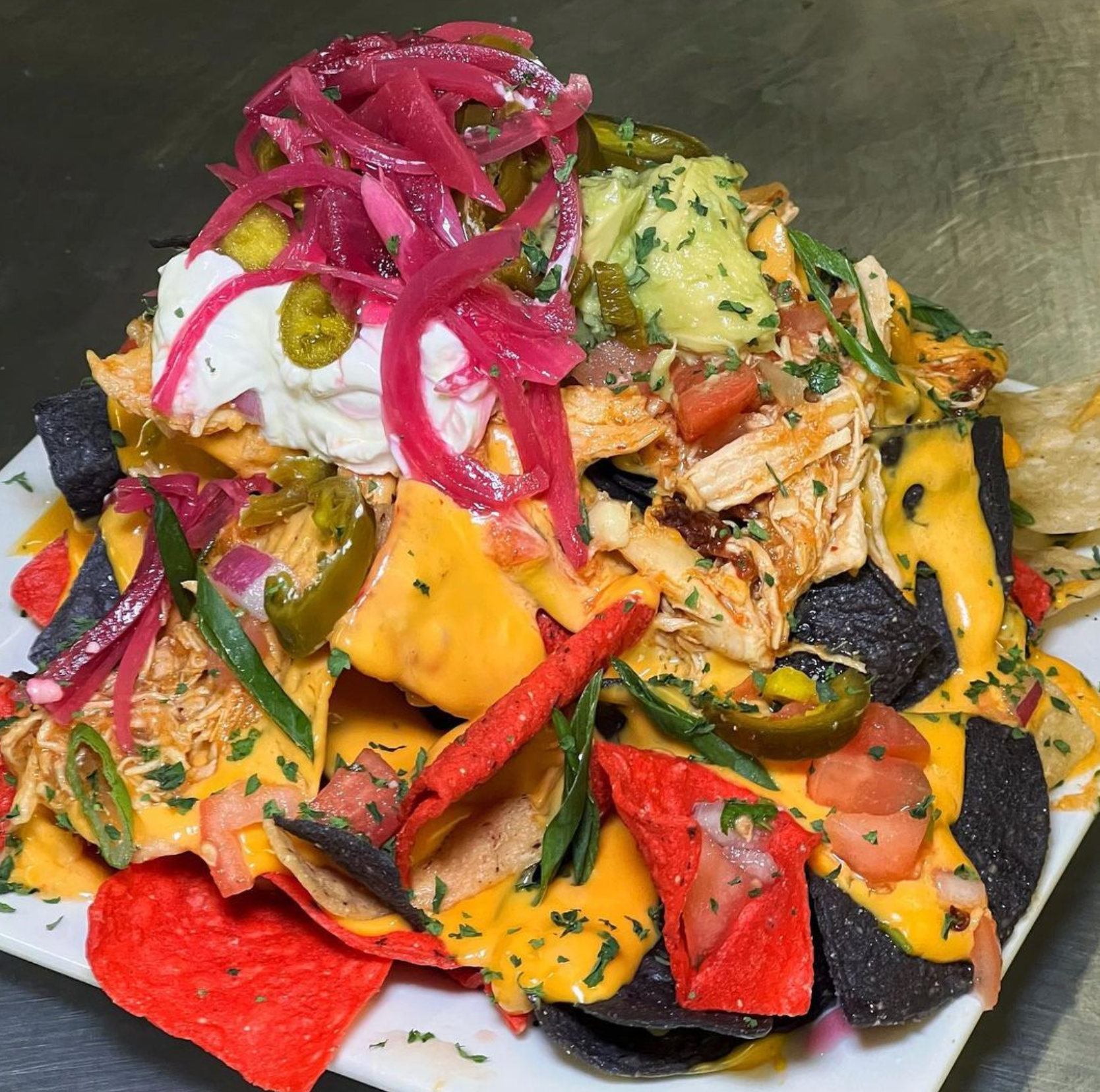 A plate of nachos with a lot of toppings on it