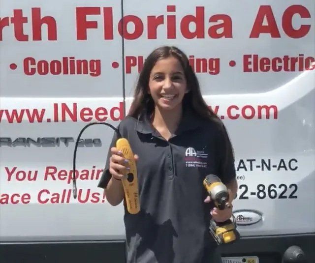 North Florida AC Employee stands in front of service van holding power drill and electrical tools