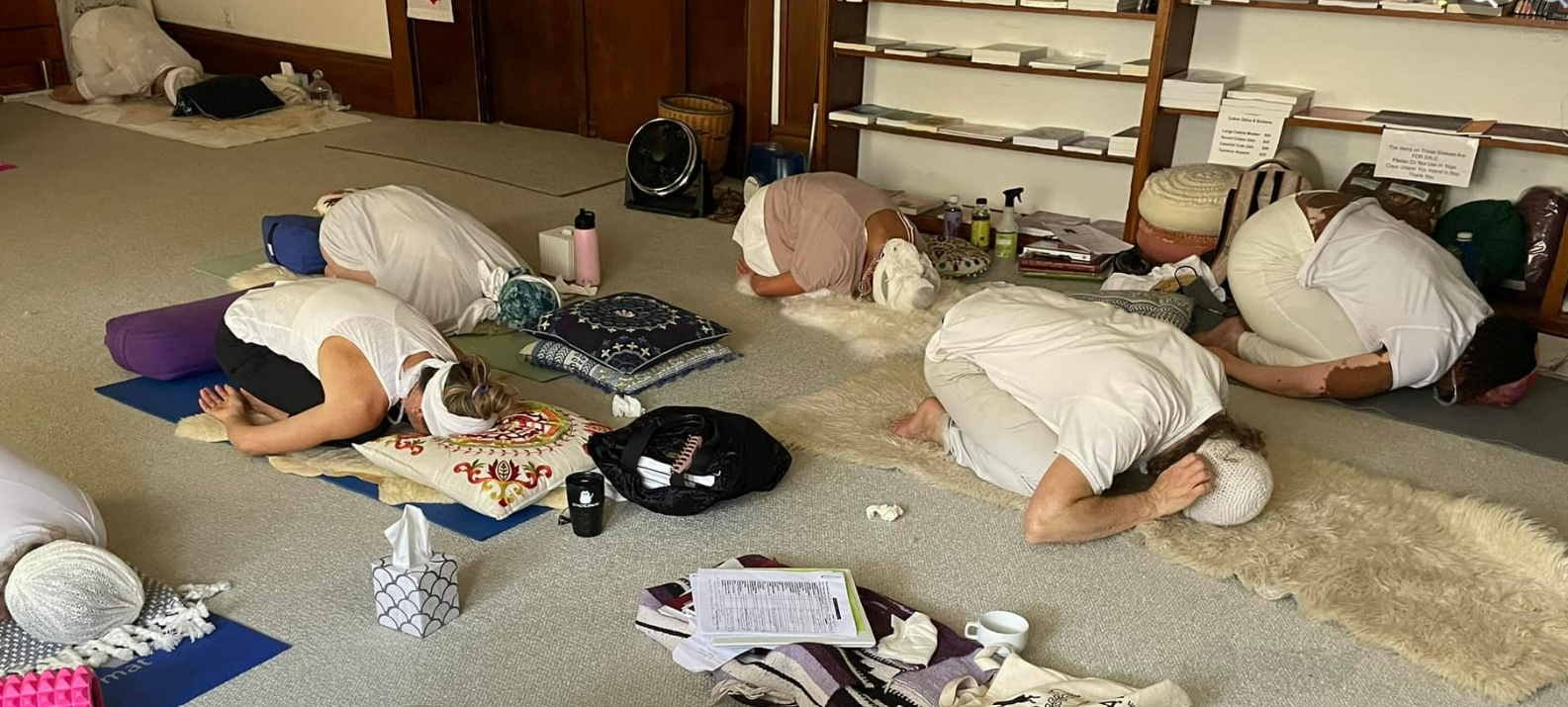 A group of people are kneeling on the floor in a room.