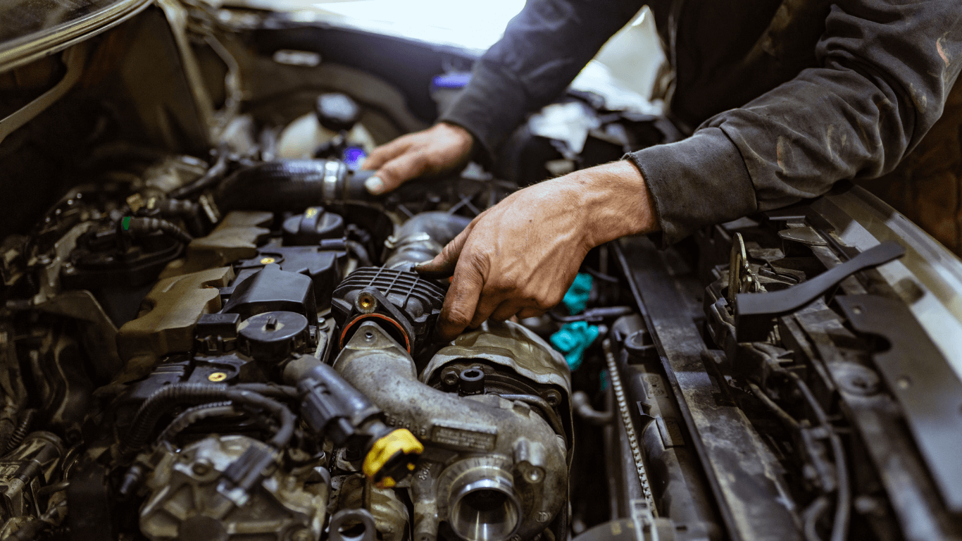 mechanic under hood of a car