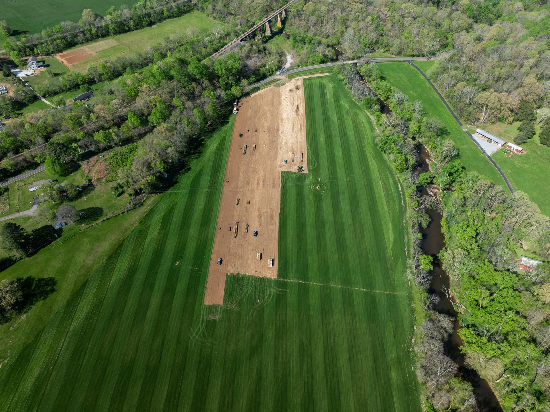 An aerial view of a baseball field surrounded by trees and grass.