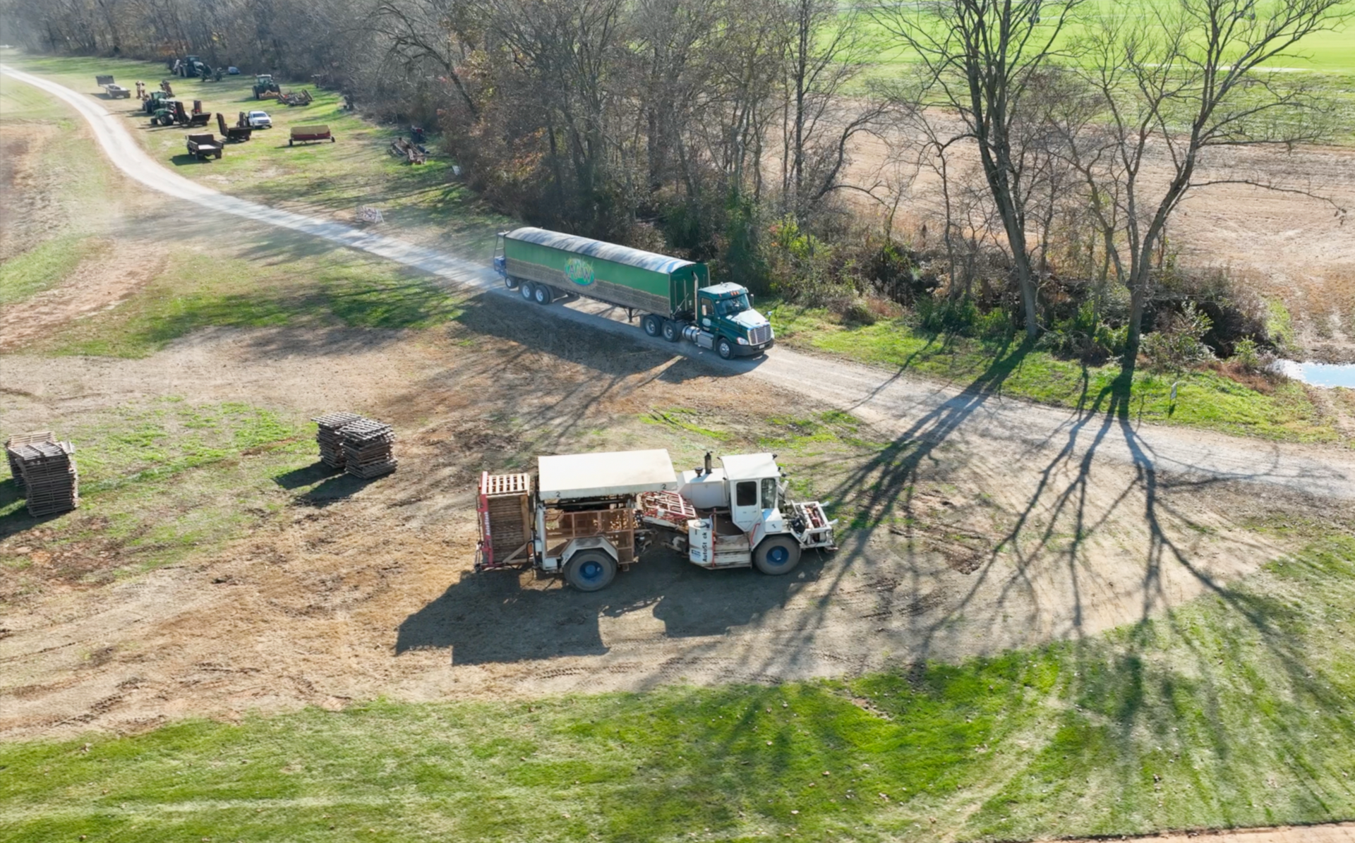 An aerial view of a truck driving down a dirt road.