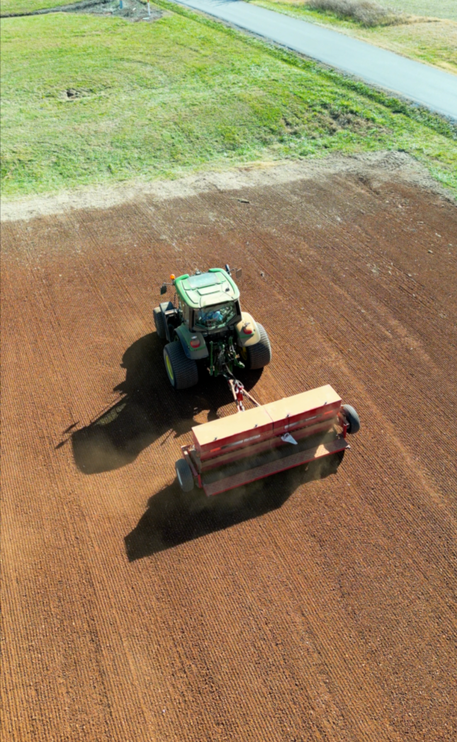 An aerial view of a tractor plowing a field.