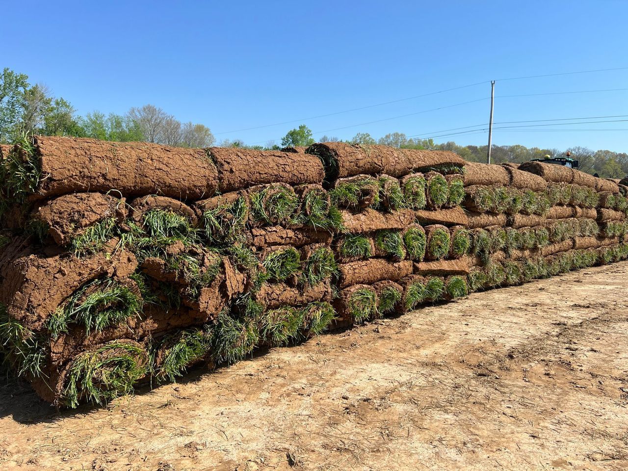 A large pile of turf is stacked on top of each other in a field.