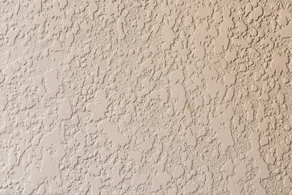 Close-up of a beige textured stucco wall