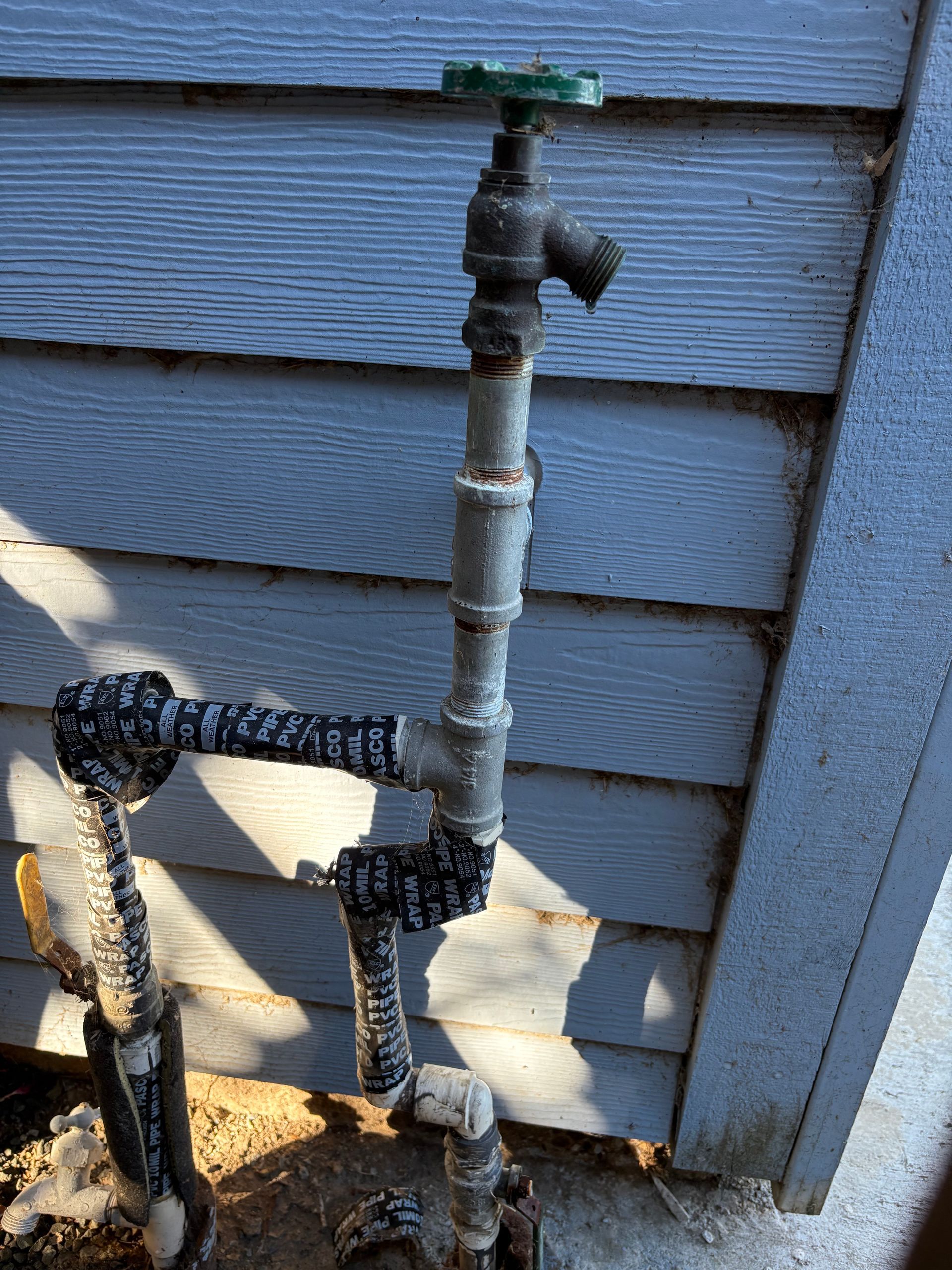 Outdoor water spigot on a siding wall