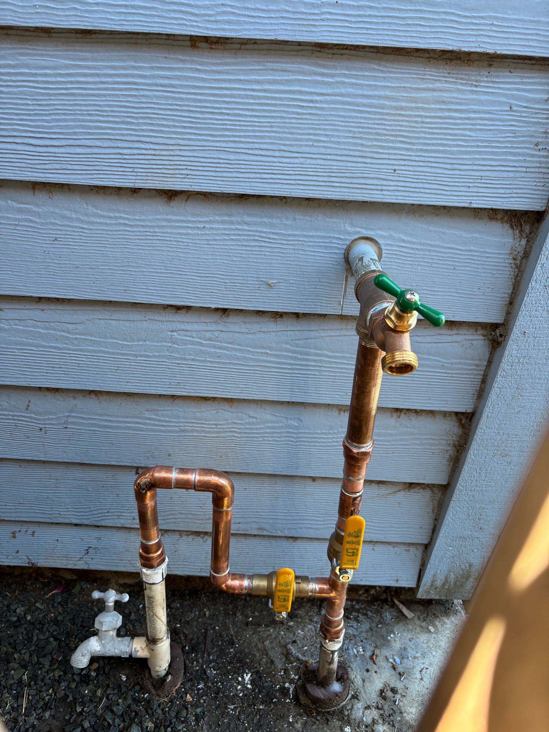 Copper pipes and faucets on a building's exterior