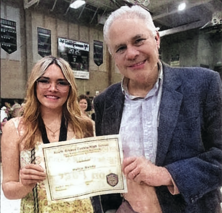 A man and a woman are standing next to each other holding a certificate