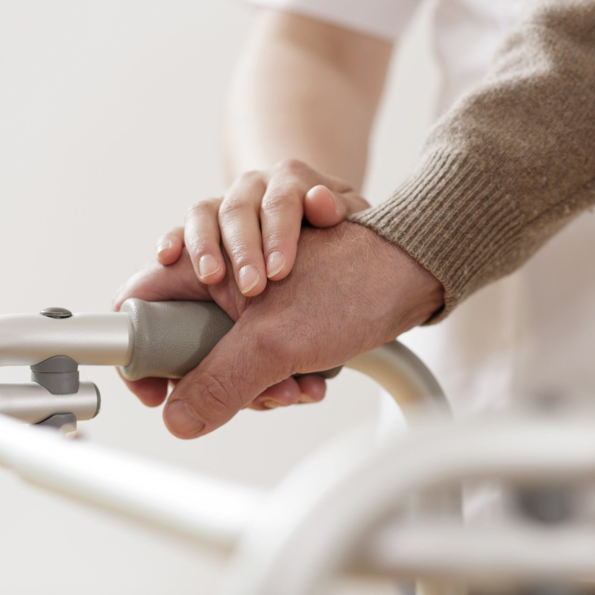 A person holding another person 's hand while using a walker