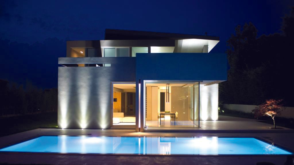 Una casa con una piscina di fronte di notte