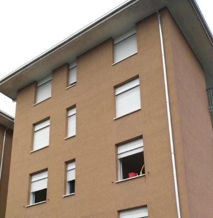 Un edificio marrone con persiane bianche alle finestre