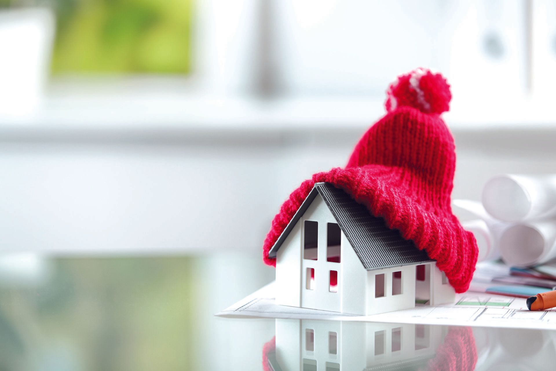 Una casa modello con un cappello rosso in cima.