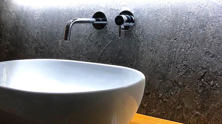 Un lavandino del bagno con un rubinetto montato a parete.