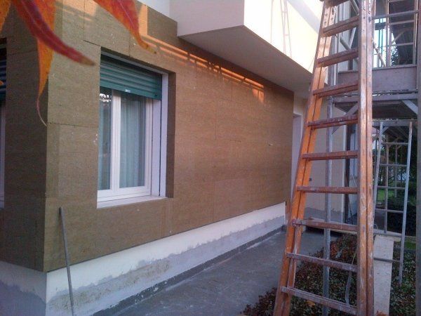 Una scala è appoggiata al lato di un edificio