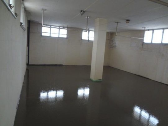 Una grande stanza vuota con un pilastro al centro