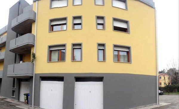 Un edificio giallo e grigio con molte finestre