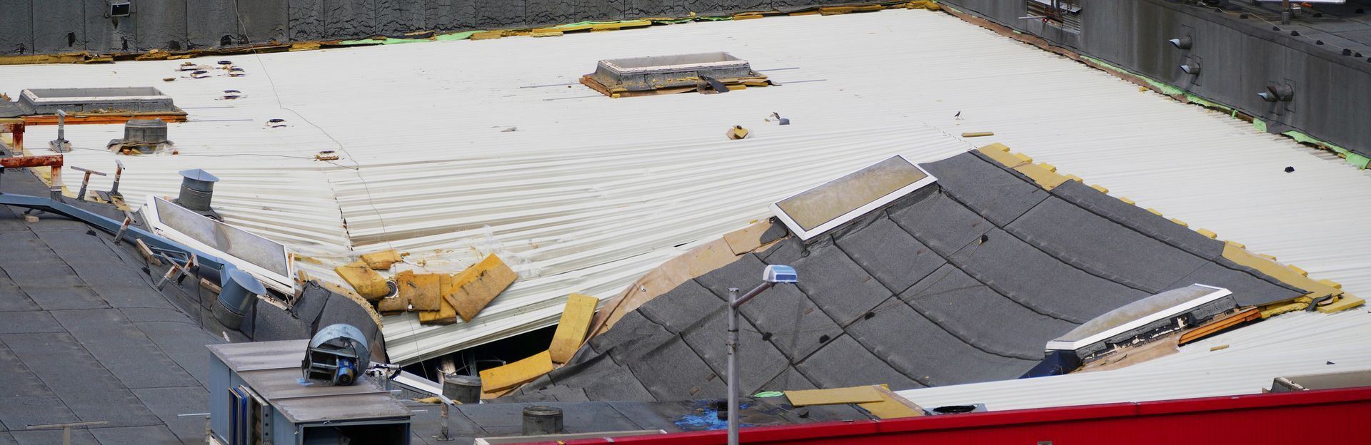 An aerial view of a building under construction with a white roof